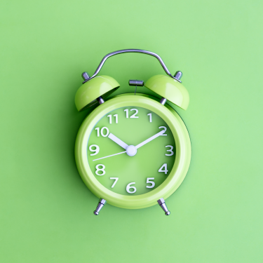 Lime green alarm clock on lime green background
